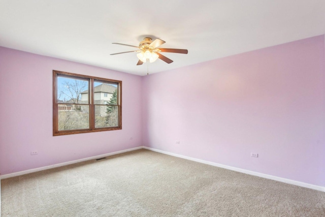 carpeted spare room with a ceiling fan, baseboards, and visible vents