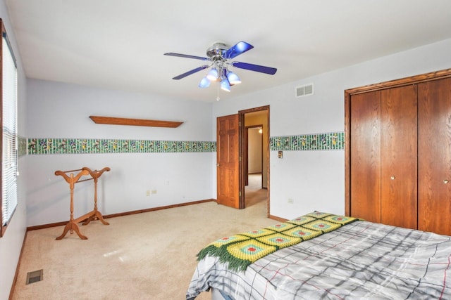 carpeted bedroom featuring a ceiling fan, a closet, baseboards, and visible vents