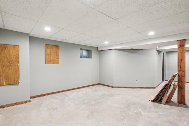 finished below grade area featuring baseboards, a drop ceiling, and recessed lighting