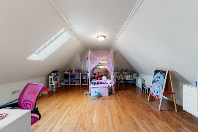 game room featuring hardwood / wood-style flooring, lofted ceiling with skylight, and visible vents