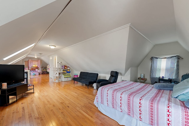 bedroom with vaulted ceiling and hardwood / wood-style floors