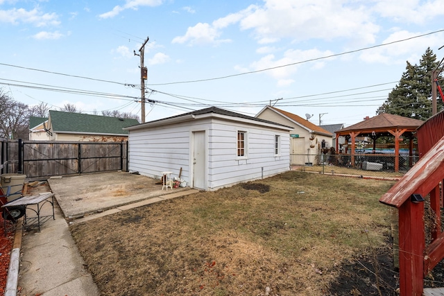 exterior space featuring a patio, an outdoor structure, a gazebo, and a fenced backyard