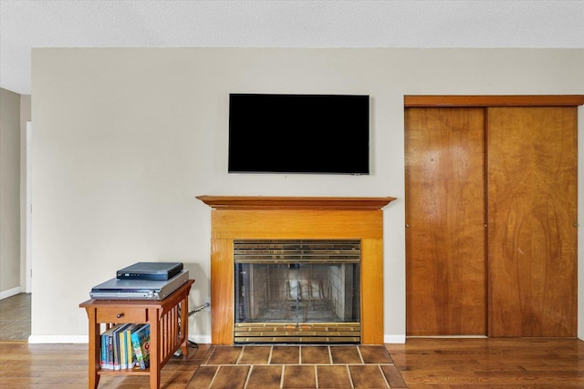 interior details with baseboards, a glass covered fireplace, and wood finished floors