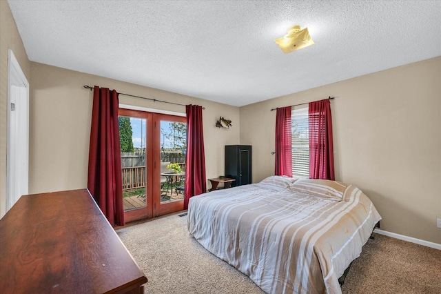 carpeted bedroom with a textured ceiling and access to exterior