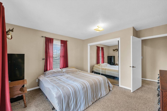 carpeted bedroom featuring a closet and baseboards