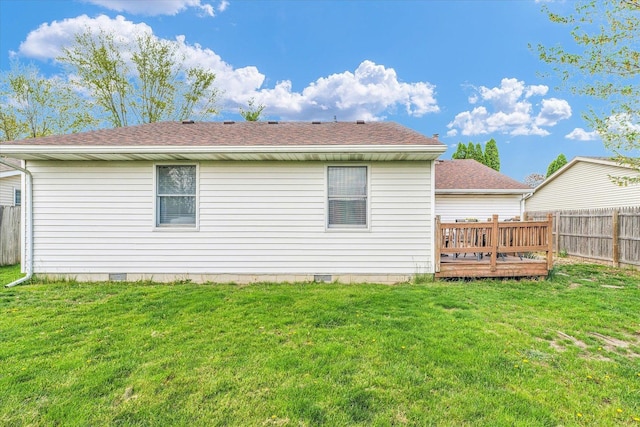 back of property featuring a fenced backyard, a shingled roof, and a yard