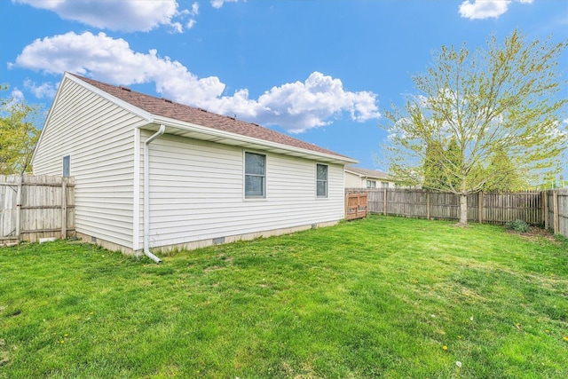 view of side of home featuring a fenced backyard, a yard, and crawl space