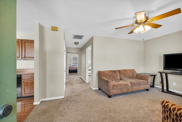 living area with baseboards, ceiling fan, light carpet, and visible vents