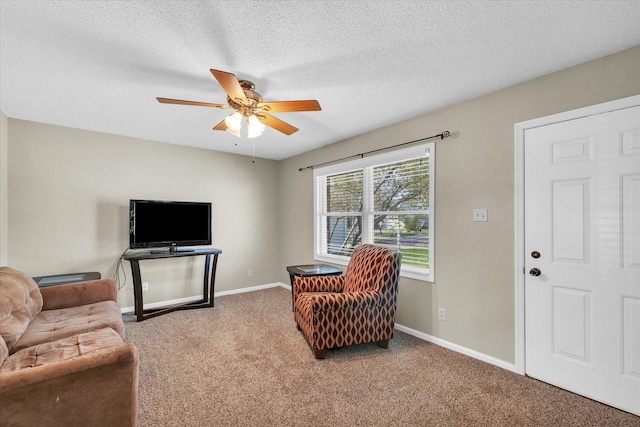 living area with a ceiling fan, a textured ceiling, baseboards, and carpet floors