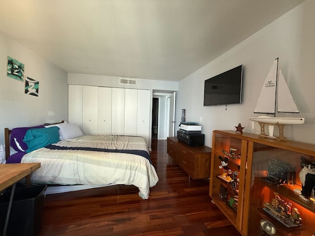 bedroom with a closet, visible vents, and wood finished floors