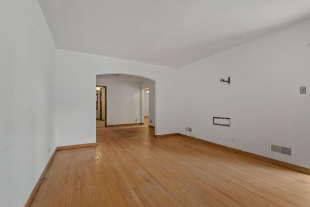 10129 S Indiana Ave, Chicago, IL 60628 - unfurnished room with arched walkways, baseboards, light wood-style flooring, and visible vents