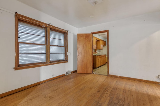 10129 S Indiana Ave, Chicago, IL 60628 - unfurnished room with light wood finished floors, baseboards, and visible vents