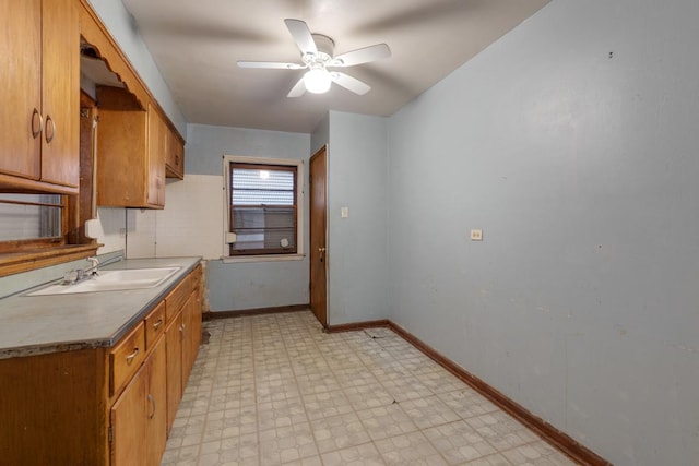 10129 S Indiana Ave, Chicago, IL 60628 - kitchen with brown cabinets, a ceiling fan, a sink, light floors, and baseboards
