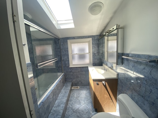 5014 W Strong St, Chicago, IL 60630 - full bathroom featuring a skylight, toilet, tile walls, vanity, and combined bath / shower with glass door