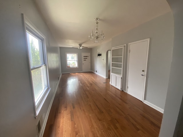 5014 W Strong St, Chicago, IL 60630 - unfurnished dining area featuring a chandelier, arched walkways, baseboards, and wood finished floors