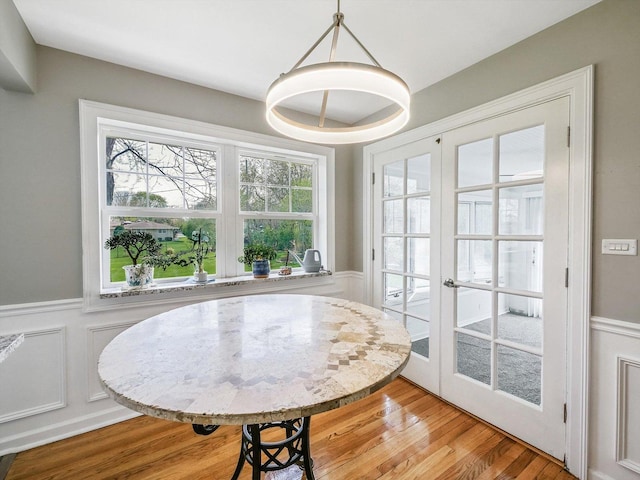 dining room featuring a wainscoted wall, french doors, and plenty of natural light