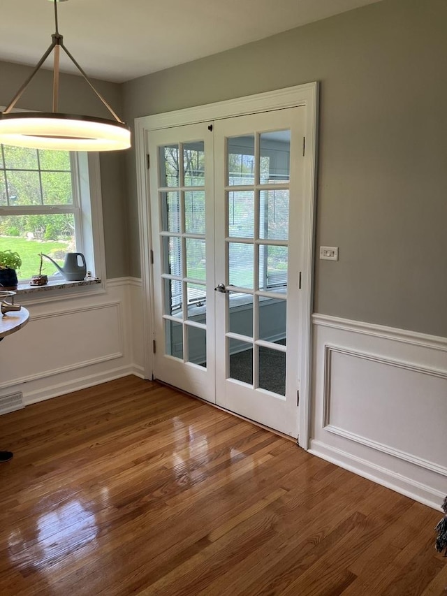 doorway featuring a healthy amount of sunlight, french doors, visible vents, and a wainscoted wall