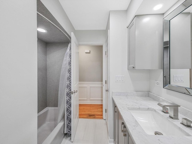 bathroom with wainscoting, vanity, and shower / tub combo