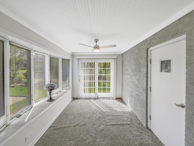 unfurnished sunroom with brick wall and carpet
