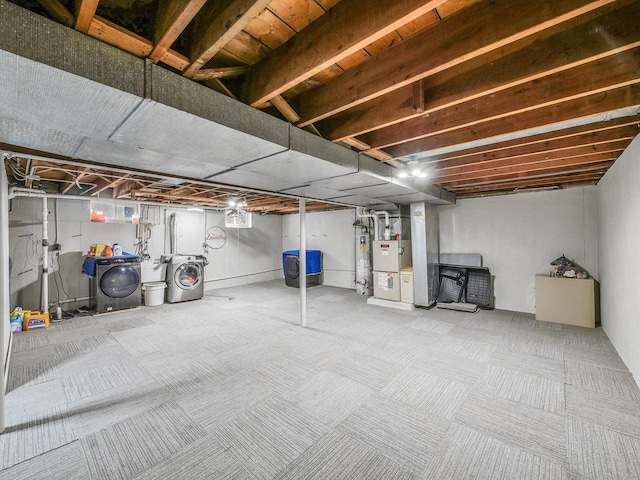 basement featuring heating unit, water heater, washing machine and dryer, and carpet floors