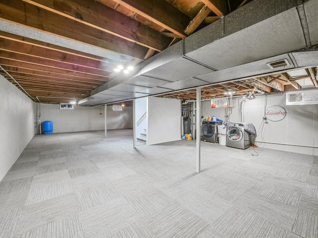 finished below grade area with carpet flooring, stairway, washing machine and dryer, and visible vents