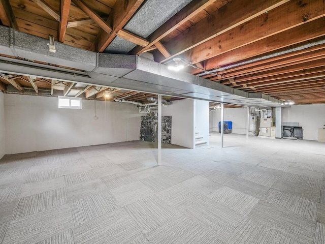 below grade area featuring water heater and carpet floors