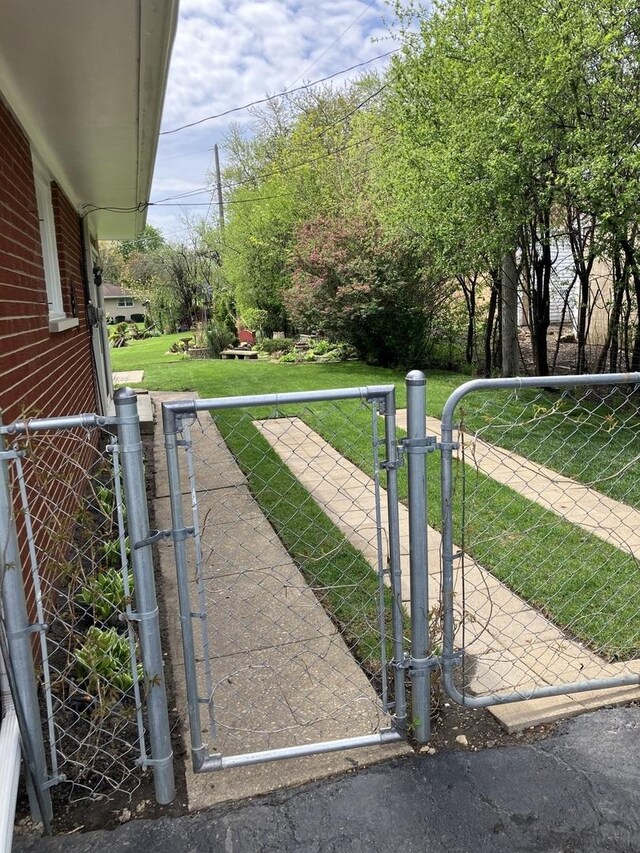 view of gate featuring a yard and fence
