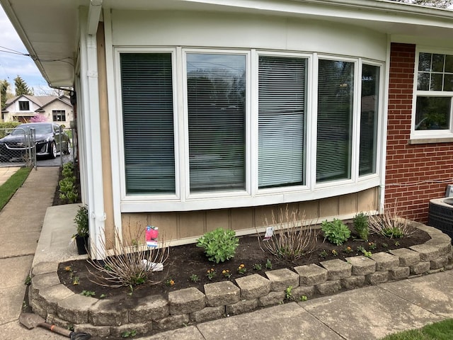 view of side of property with brick siding and central AC unit