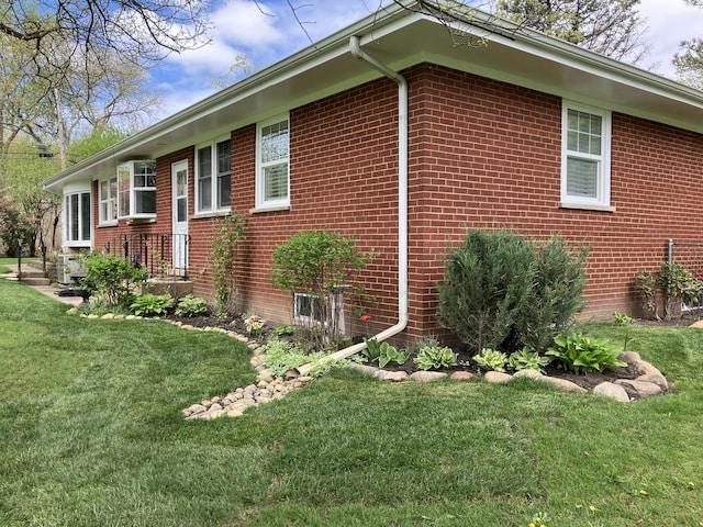 view of home's exterior with a yard and brick siding