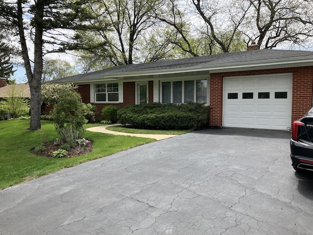 ranch-style house featuring an attached garage, brick siding, driveway, a front yard, and a chimney