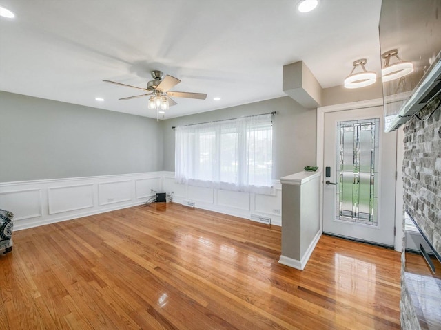 entryway featuring recessed lighting, visible vents, ceiling fan, a wainscoted wall, and light wood-type flooring