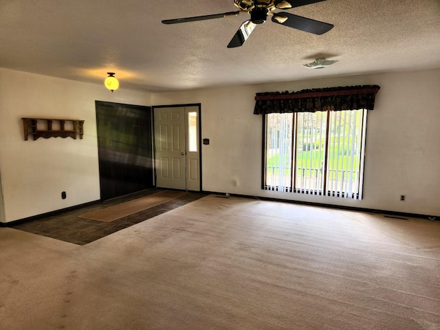unfurnished living room featuring carpet floors, baseboards, a ceiling fan, and a textured ceiling