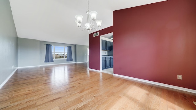unfurnished dining area with light wood-style flooring, baseboards, visible vents, a chandelier, and high vaulted ceiling