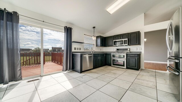 kitchen featuring lofted ceiling, light tile patterned floors, visible vents, a sink, and stainless steel appliances