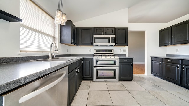 kitchen with hanging light fixtures, light tile patterned floors, a sink, stainless steel appliances, and lofted ceiling