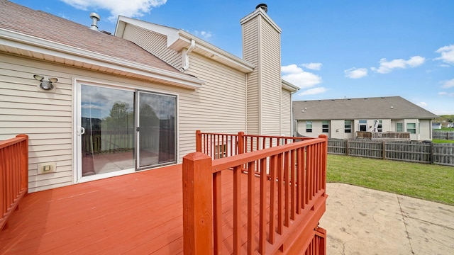 wooden terrace with a lawn, a patio area, and fence