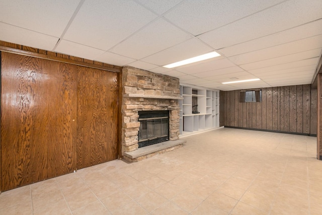 1921 Elm St, Park Ridge, IL 60068 - unfurnished living room featuring a paneled ceiling, wooden walls, a stone fireplace, and built in features