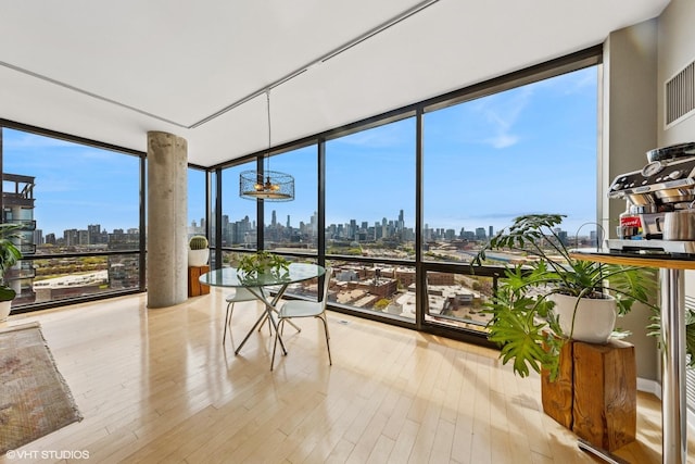 unfurnished sunroom with a skyline view and a chandelier
