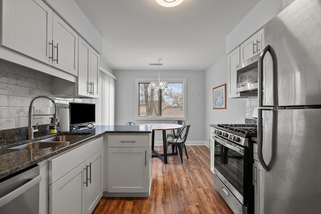 5177 Coventry Ln Unit D, Gurnee, IL 60031 - kitchen featuring a sink, dark stone countertops, dark wood-type flooring, stainless steel appliances, and tasteful backsplash
