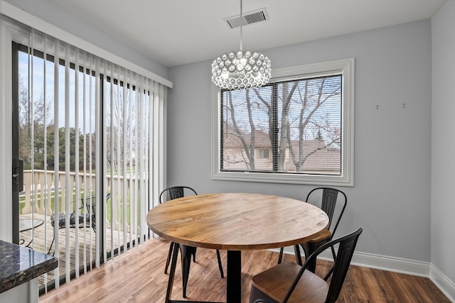 5177 Coventry Ln Unit D, Gurnee, IL 60031 - dining room featuring wood finished floors, a healthy amount of sunlight, visible vents, a chandelier, and baseboards