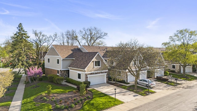 traditional-style house with a front yard, an attached garage, stone siding, and driveway