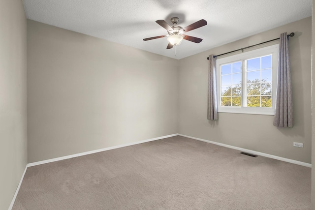 empty room with baseboards, carpet flooring, ceiling fan, and a textured ceiling