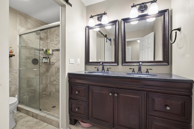 full bath with double vanity, toilet, a stall shower, and a sink