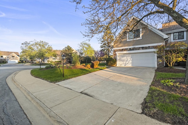 view of front of house with stone siding, a garage, driveway, and a front yard
