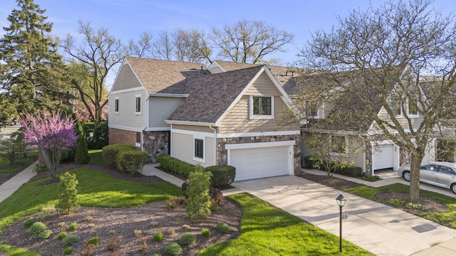 view of front of property featuring driveway, a front yard, an attached garage, stone siding, and roof with shingles