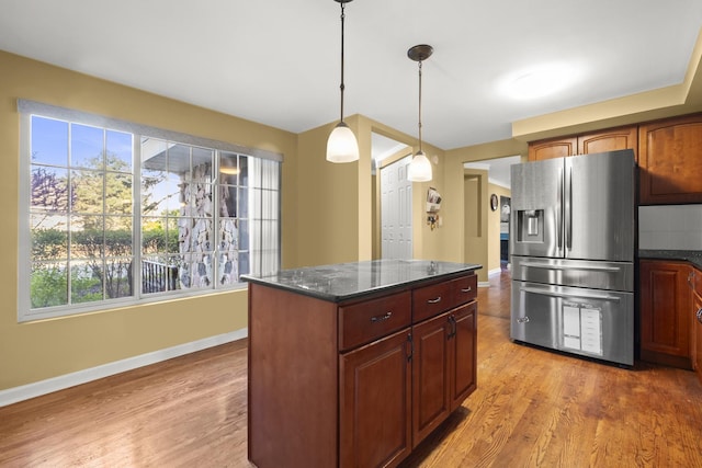 kitchen with baseboards, a healthy amount of sunlight, light wood-type flooring, and stainless steel refrigerator with ice dispenser