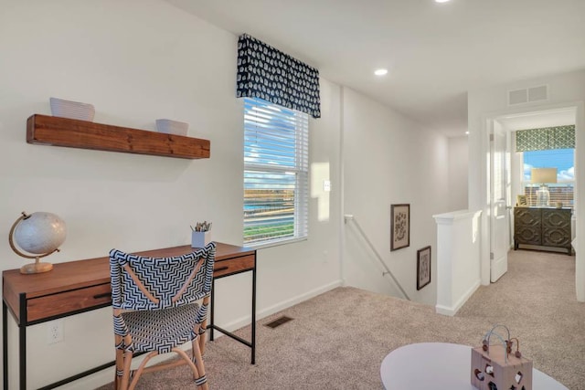 home office featuring plenty of natural light, carpet floors, and visible vents