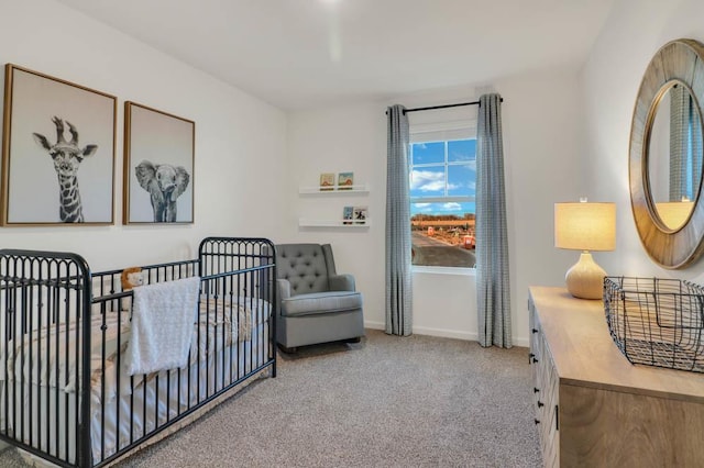 carpeted bedroom featuring baseboards and a nursery area