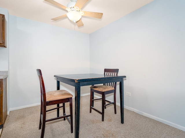 dining area with light colored carpet and baseboards