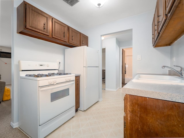 kitchen with light floors, white appliances, visible vents, a sink, and light countertops